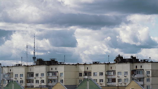 公寓楼上空翻滚的航拍灰色云层视频的预览图