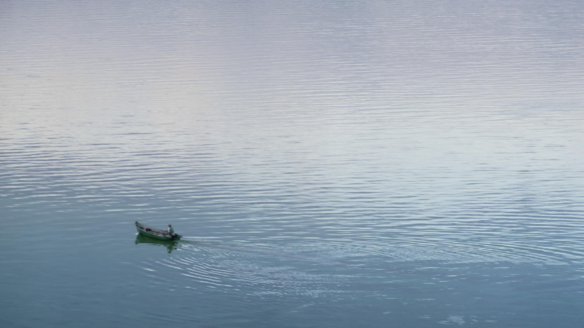 在静止的河上漂浮木船航拍视频的预览图