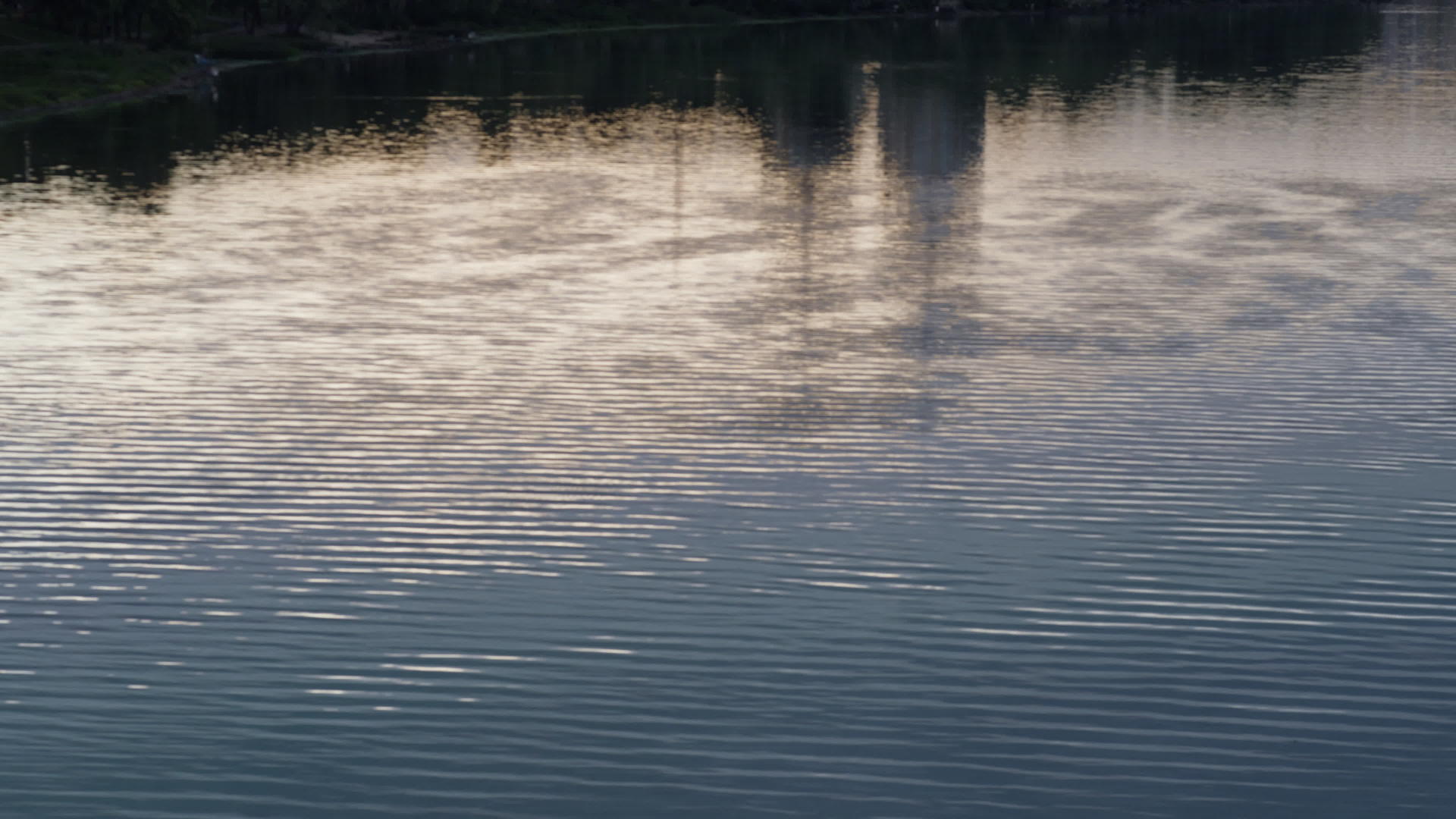 平静的河流波纹反映了城市景观的抽象航拍视频的预览图