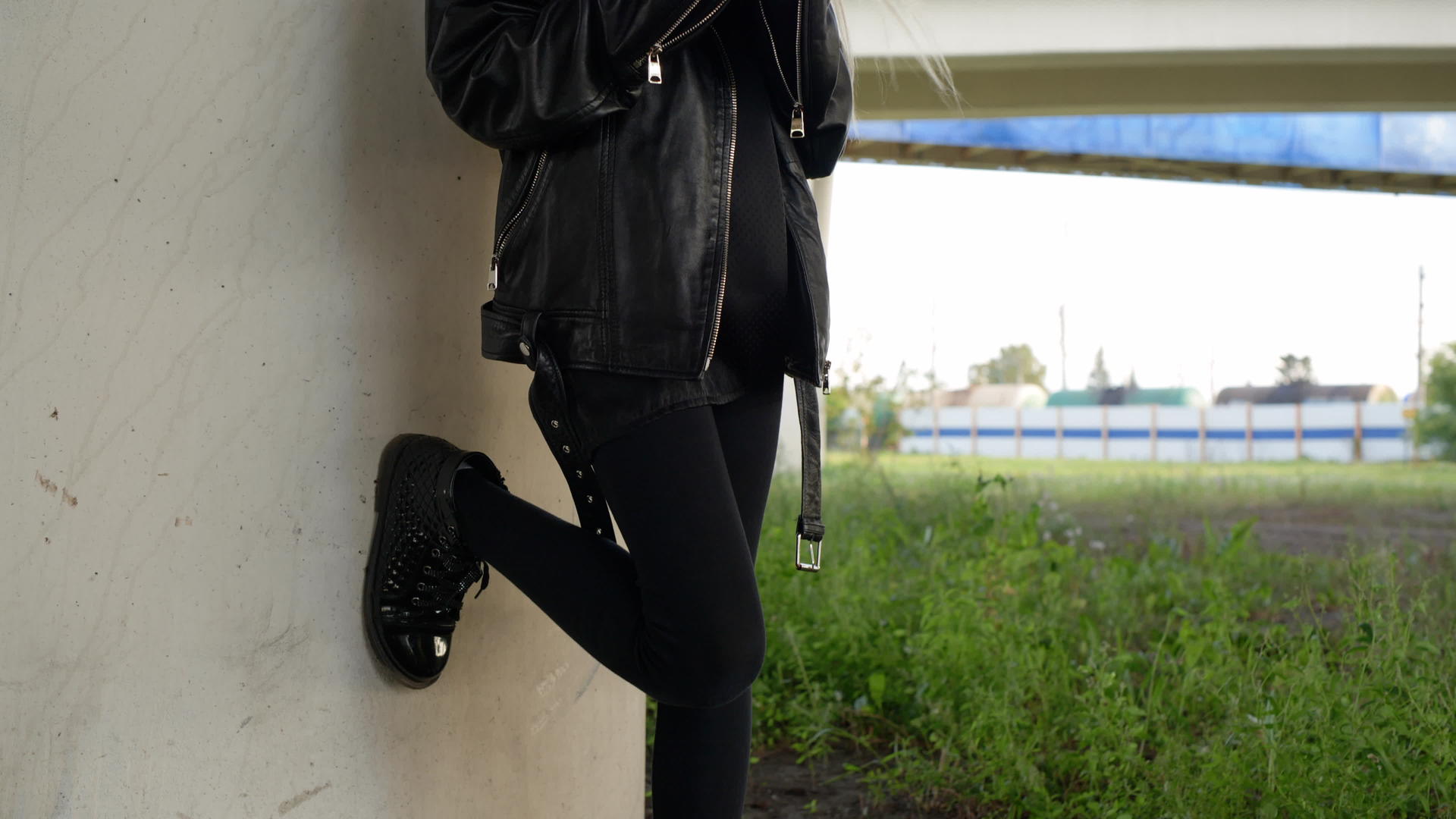 摇滚女孩穿着黑色皮夹克在户外使用手机朋克女孩在城市视频的预览图