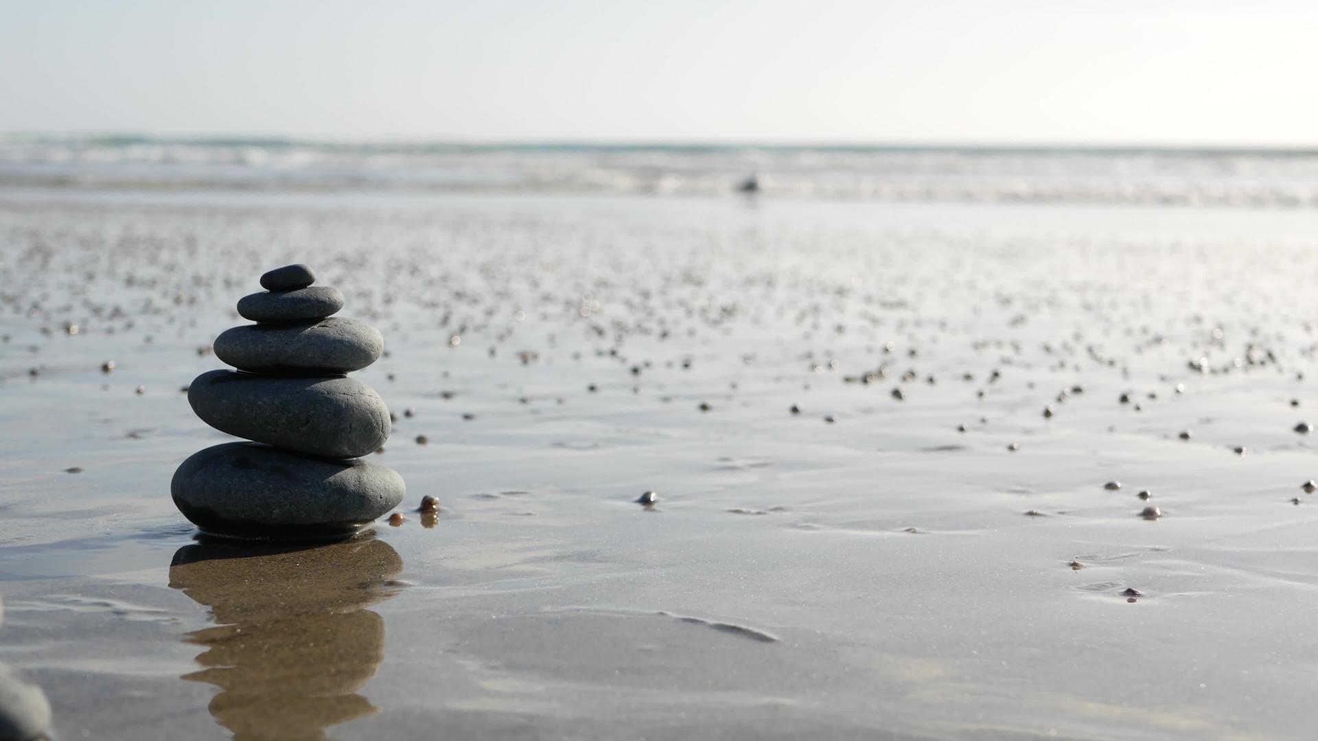 在海洋海滩上平衡岩石在海浪积岩石在沙滩上堆积岩石在沙滩上堆积岩石视频的预览图