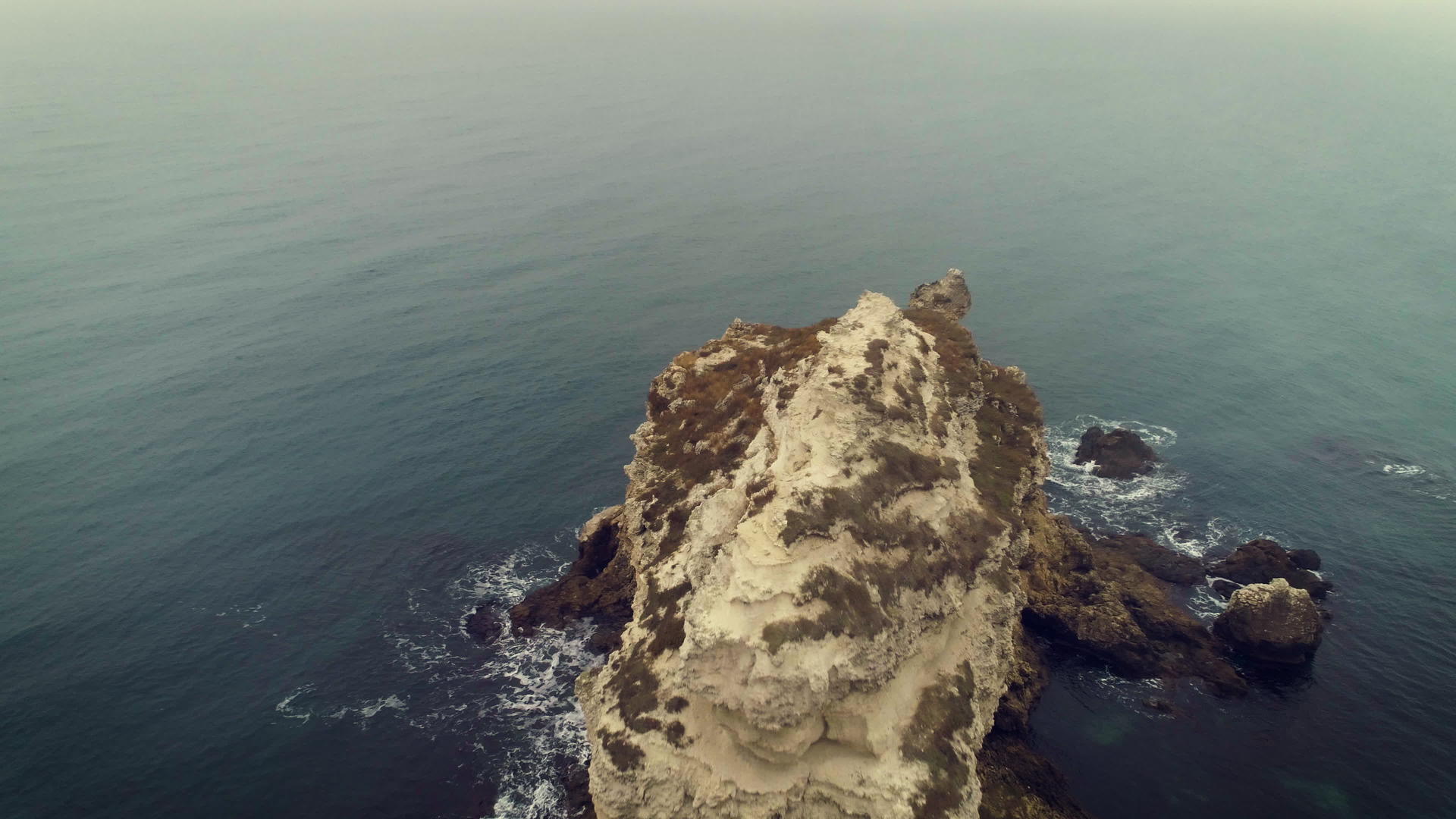 在沿海岸线悬崖断裂处以低角度向前飞行的摄像机在空中倾斜视频的预览图