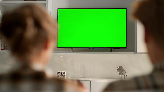 朋友们在家玩绿色电视屏幕视频游戏视频的预览图