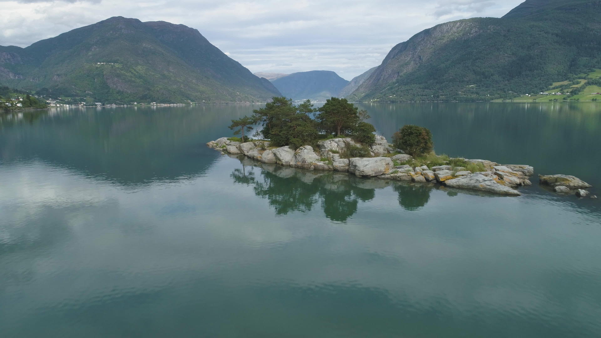 低空飞越峡湾岛屿的背景是绿色的山脉挪威的卢斯特拉峡湾在水中视频的预览图