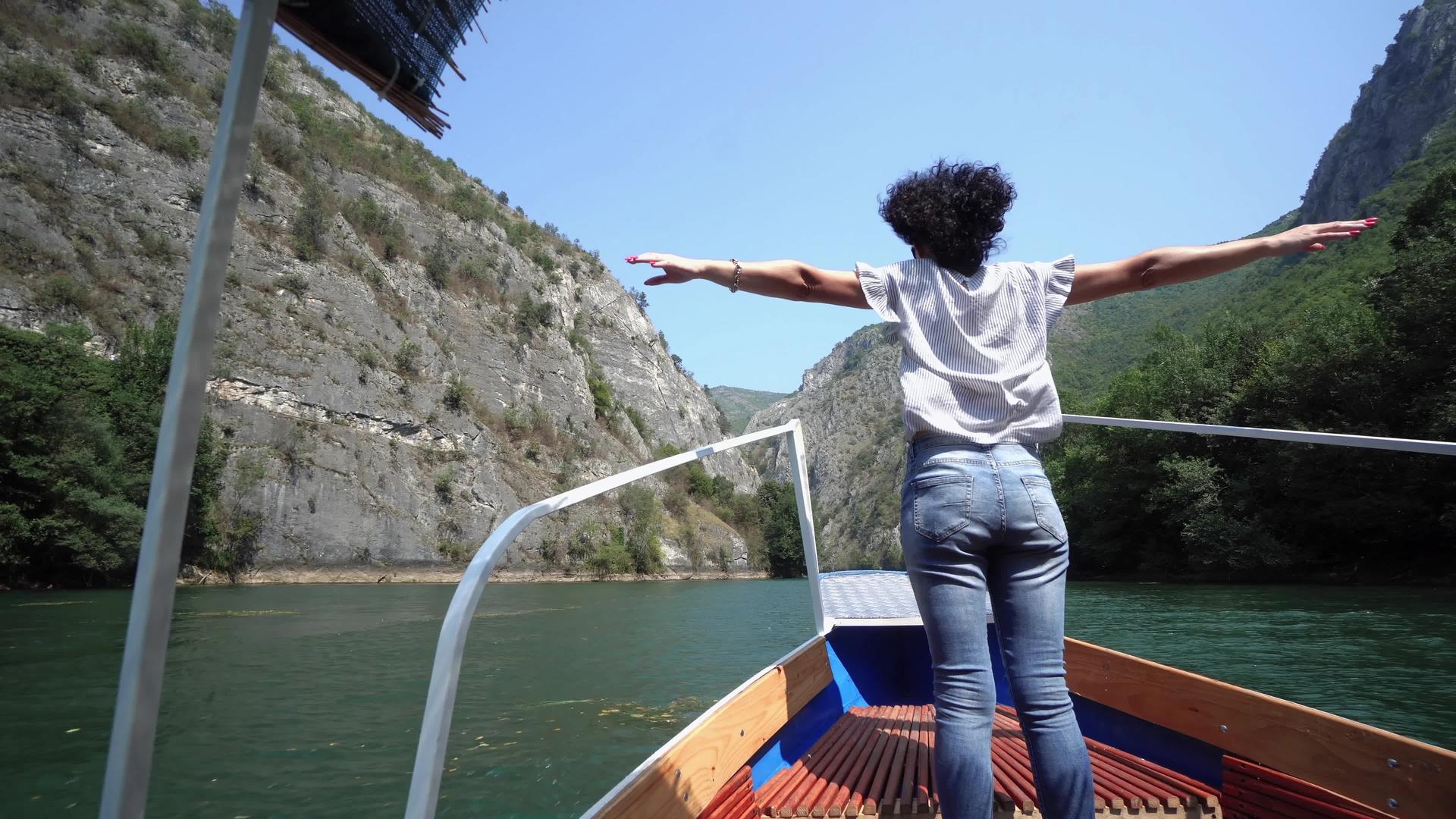 女人站在船上张开双臂享受夏风的喜悦视频的预览图