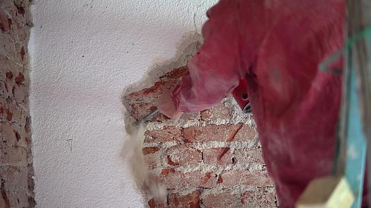 建筑工人用电锤拆除旧砖墙的废砖墙视频的预览图