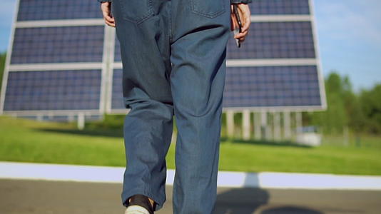 穿着蓝色牛仔裤的工人走到太阳能电池组视频的预览图