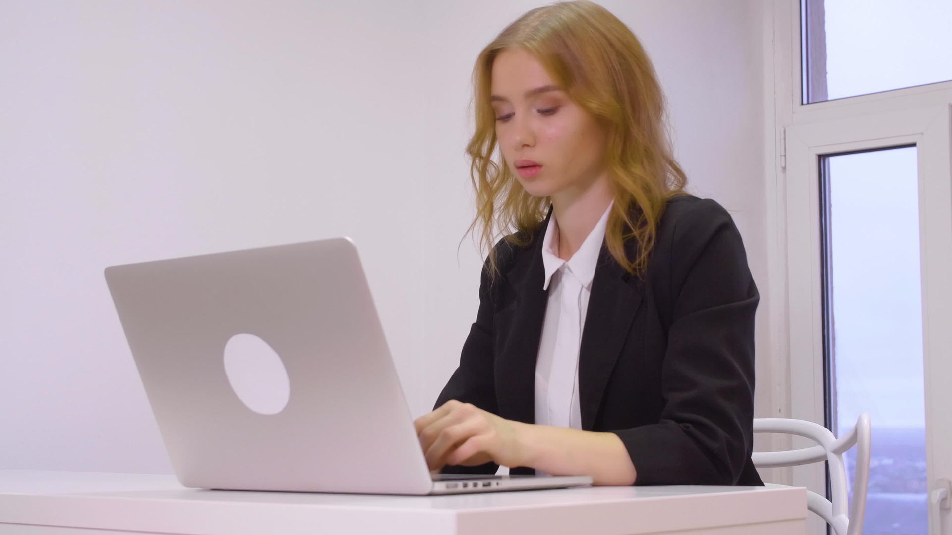 在办公室工作场所用笔记本电脑工作的年轻女商人视频的预览图