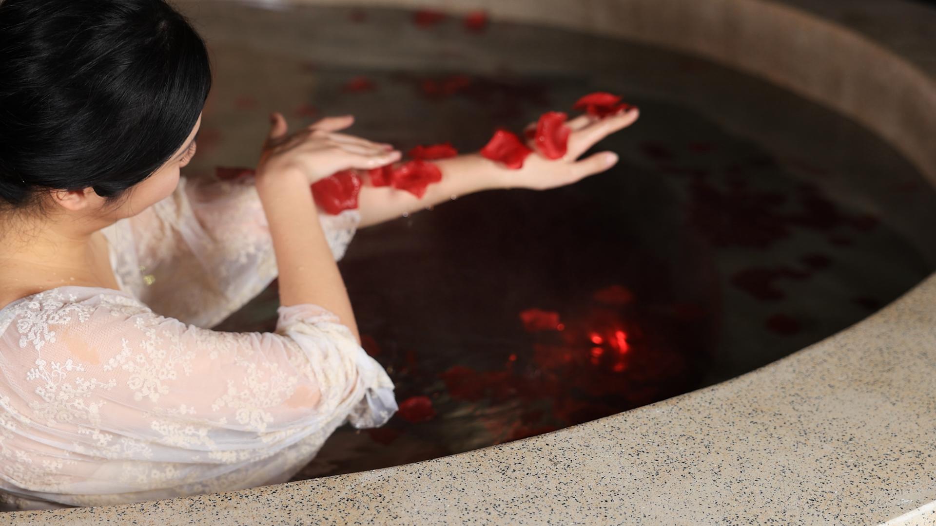 花瓣池中泡温泉的年轻女性视频的预览图