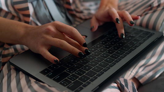 女士穿着睡衣特写笔记本电脑视频的预览图