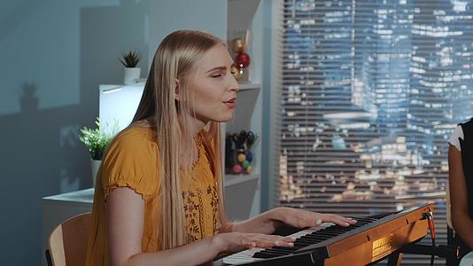 在家庭录音室排练乐队时唱一首金发女歌演奏键盘视频的预览图