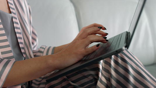 女人的手在家里用笔记本电脑视频的预览图