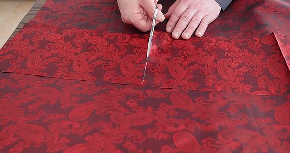 时装设计师使用裁缝工具在工作室使用红色佩斯利衬里面料视频的预览图