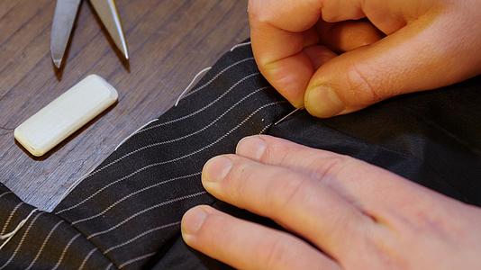 专业裁缝工匠传统缝制黑色夹克西装近镜头视频的预览图