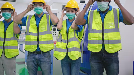 工厂工人的男女或技术人员或工程师戴着卫生面具看着相机视频的预览图