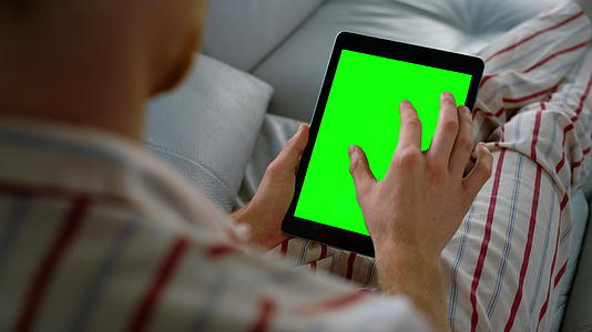 商务人士在远程家庭办公室特写镜头中触摸绿色平板电脑屏幕视频的预览图