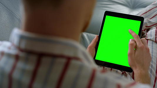 手指滚动绿色平板电脑屏幕特写视频的预览图