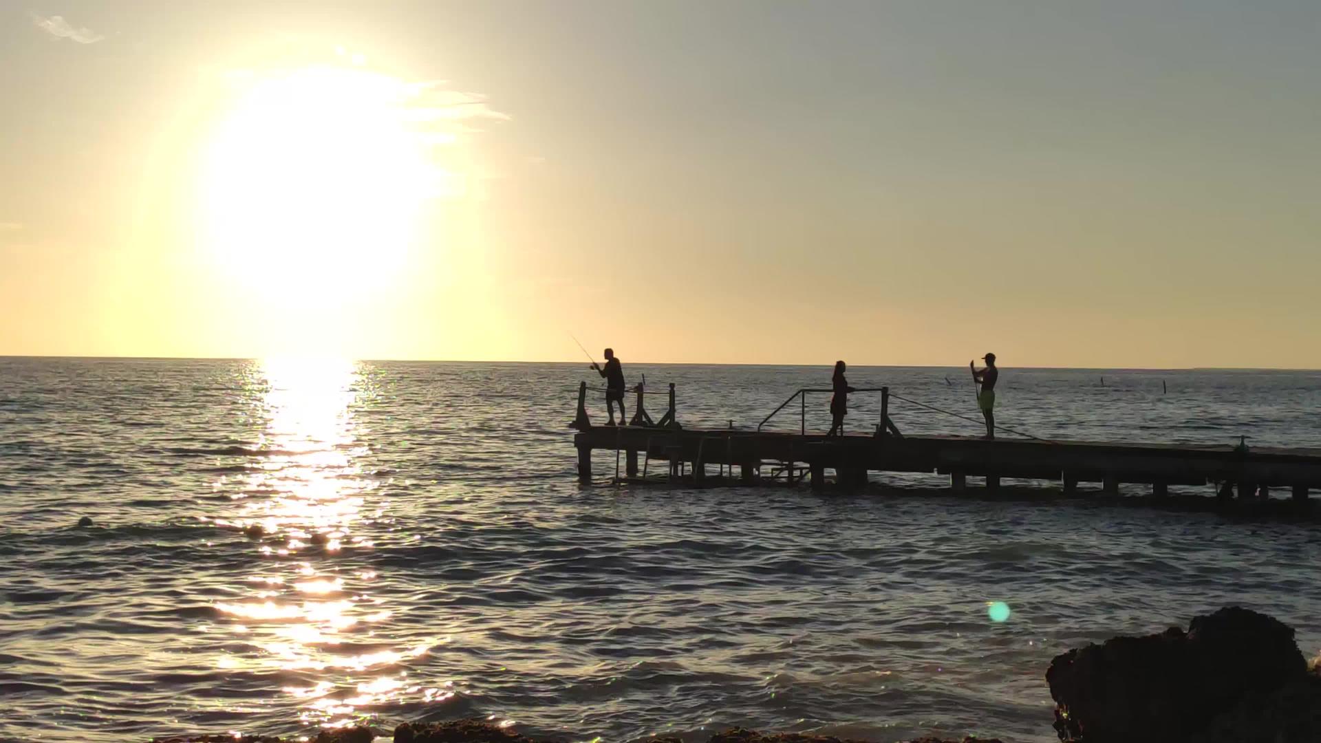 日落时码头的渔夫视频的预览图