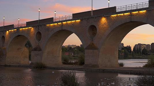 日落时与西班牙瓜迪亚纳河上的鸭子搭桥视频的预览图
