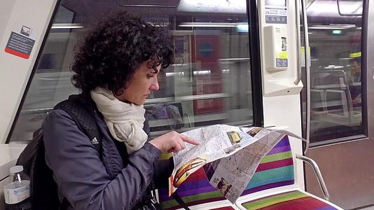 女性乘坐地铁火车在帕里斯的地下地图上看一看视频的预览图