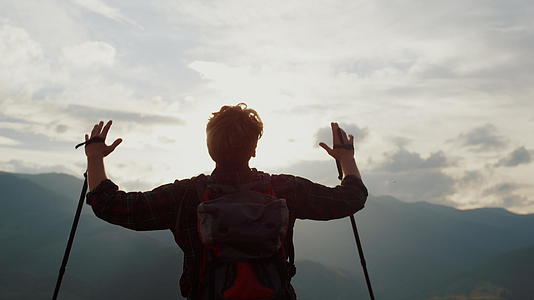 快乐的徒步旅行者向山上的天空举手视频的预览图