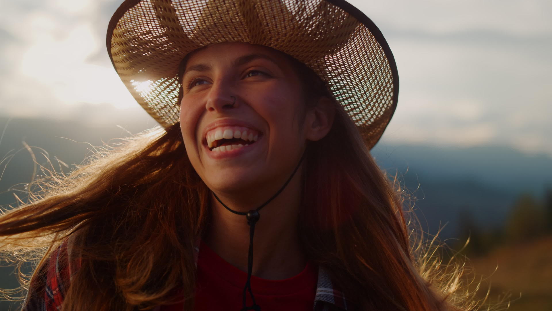 微笑的女人在山的肖像上看日落视频的预览图