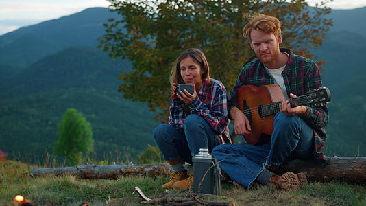 放松的恋人在自然景观中弹吉他视频的预览图
