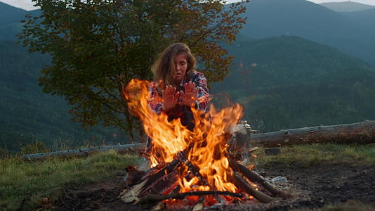 在篝火上美丽的女人双手温暖视频的预览图