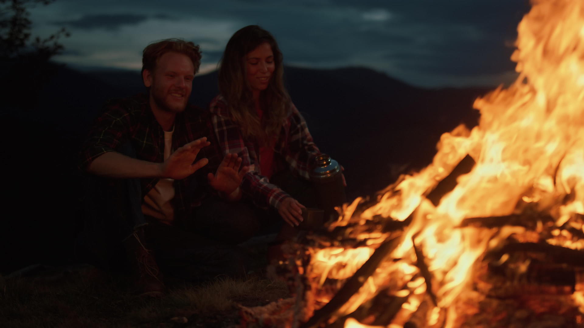 可爱的露营者在夜山放松篝火视频的预览图