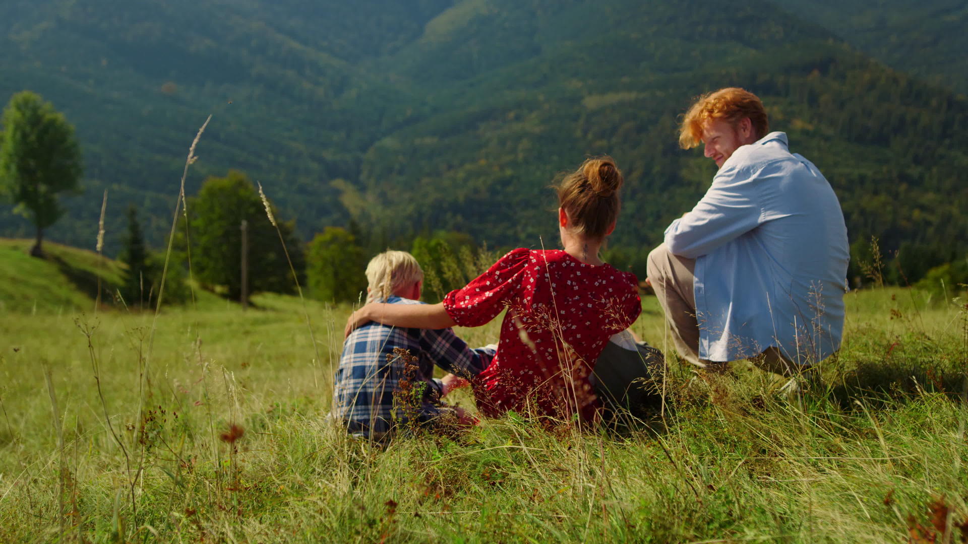 幸福的家庭放松坐在青山上视频的预览图