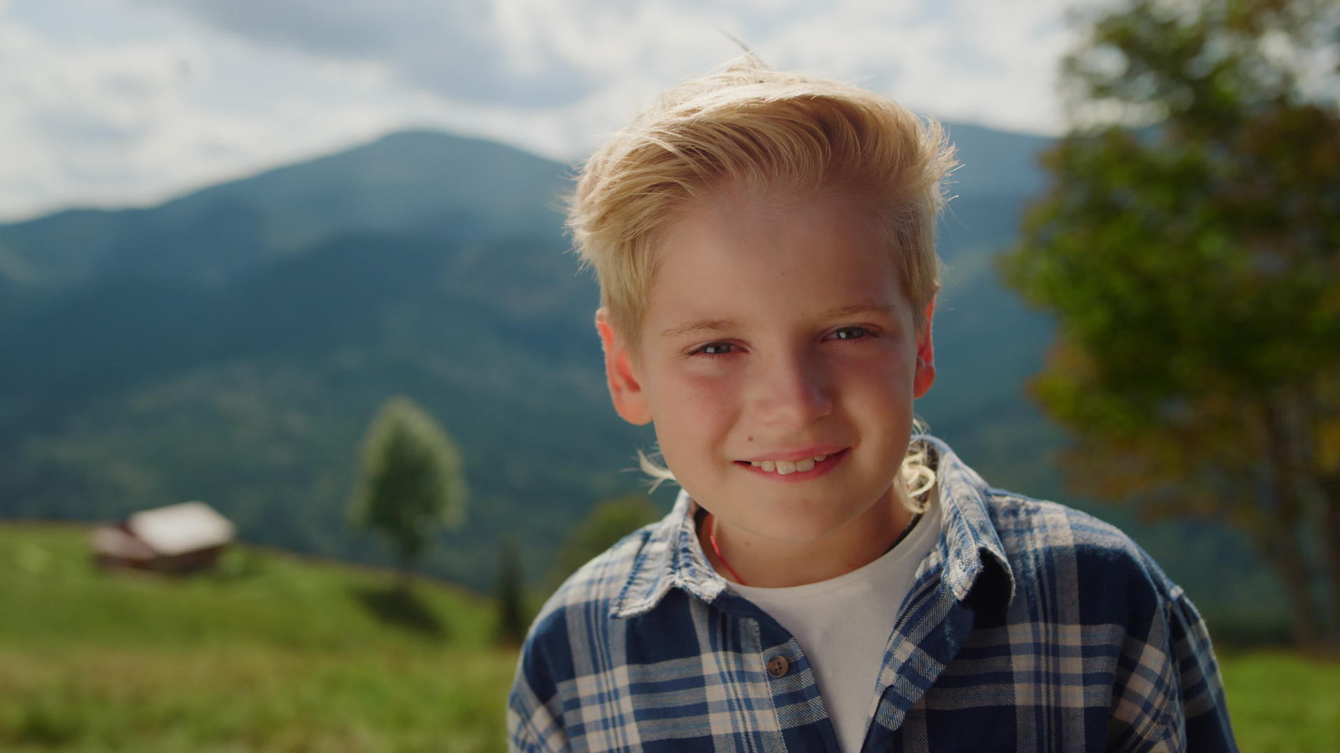 快乐肖像男孩在山里看相机视频的预览图