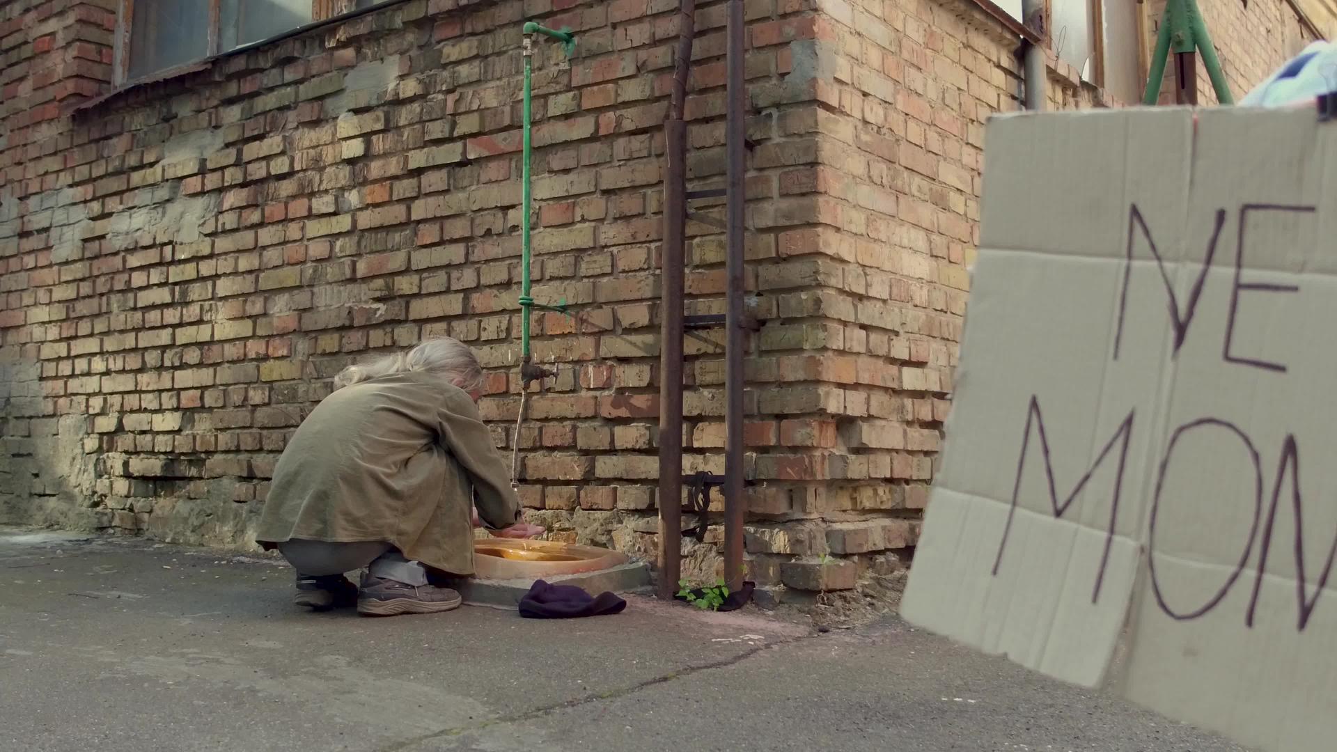 乞丐蹲在街上用水龙头洗手视频的预览图