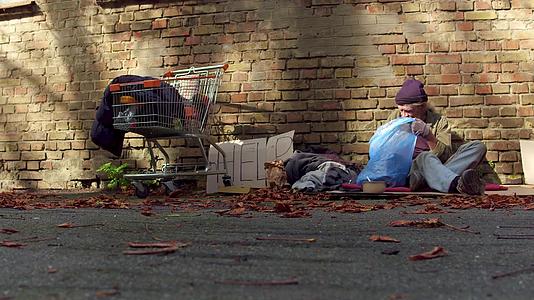 无家可归的人在垃圾袋里翻滚视频的预览图