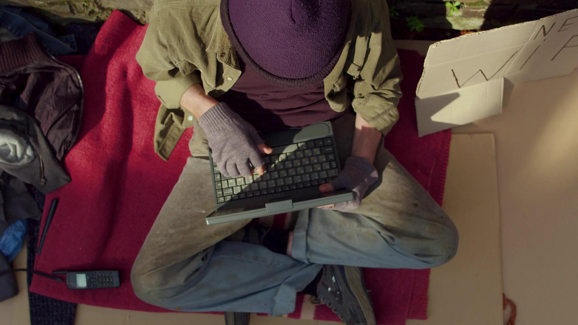 无家可归者在笔记本电脑上打字视频的预览图