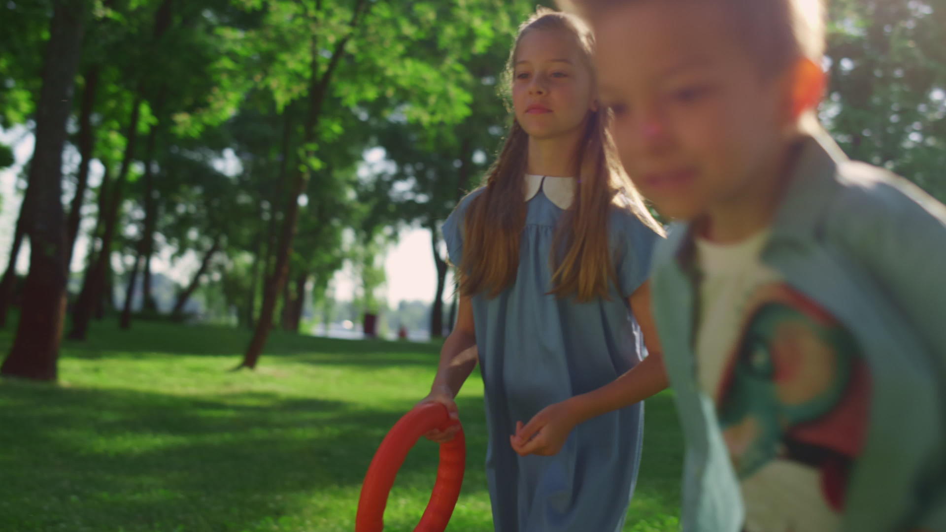 两位专注的兄弟姐妹在金色阳光公园的特写镜头中奔跑视频的预览图