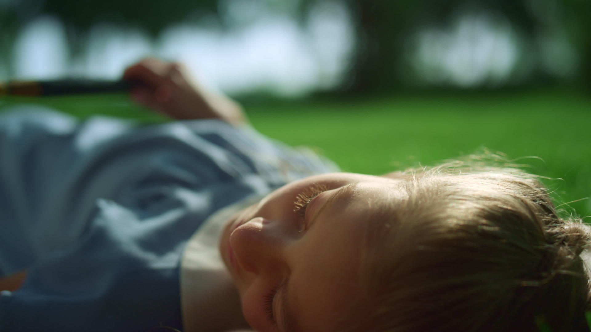 梦幻般昏昏欲睡的女孩躺在公园特写镜头的金色阳光下视频的预览图