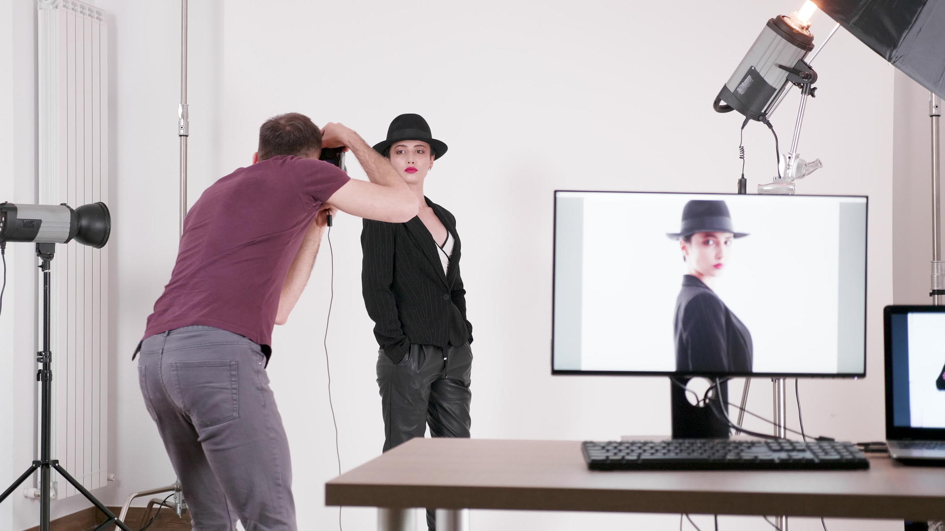 戴帽子的专业模特和摄影师拍摄她的照片视频的预览图