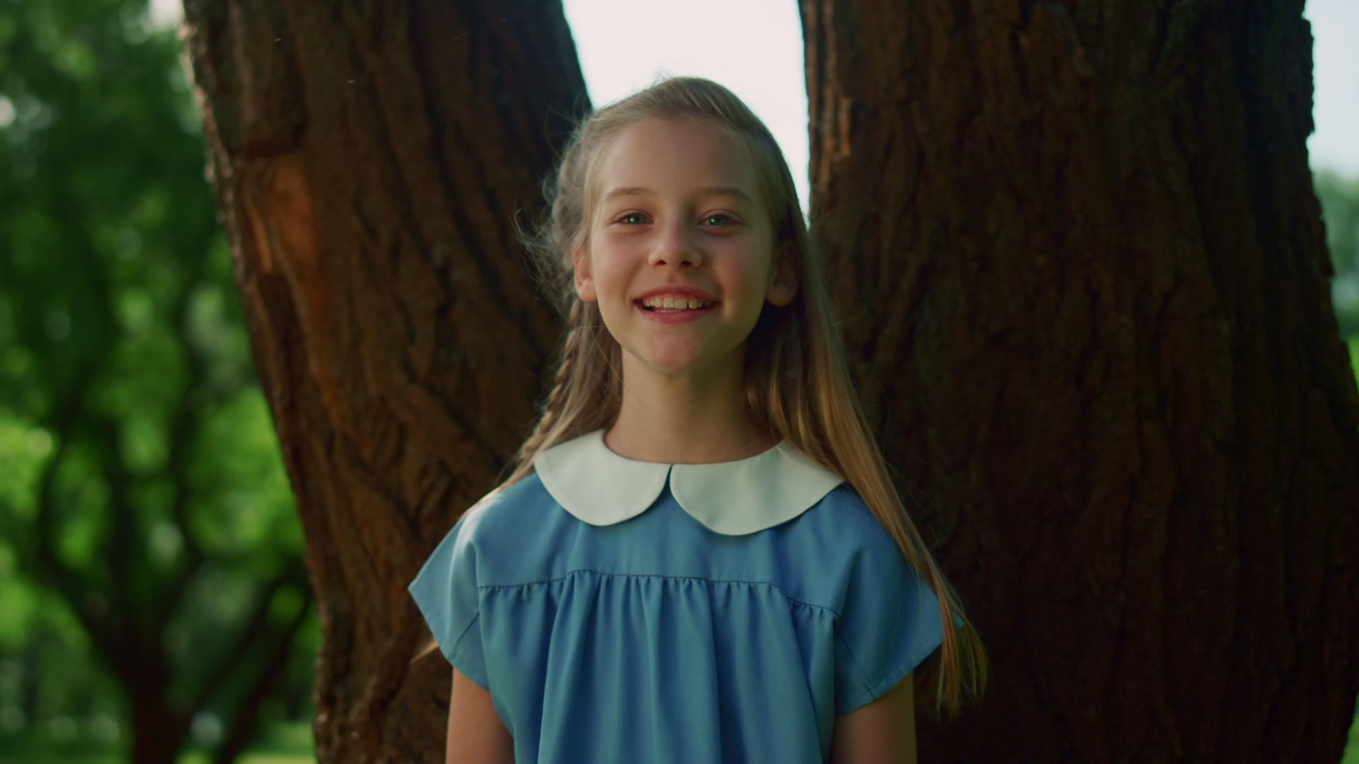 快乐的小女孩在树干上视频的预览图