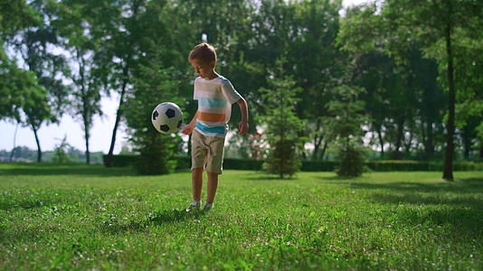 在公园里运动男孩进行足球运动视频的预览图