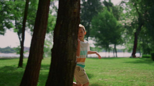 快乐的男孩在绿色公园里奔跑视频的预览图