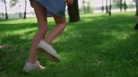儿童腿在绿草草甸上奔跑视频的预览图