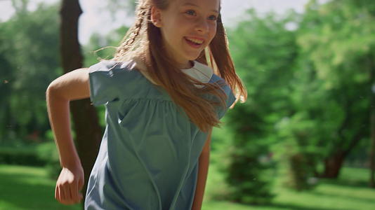微笑的女孩在柔软的草地上奔跑视频的预览图