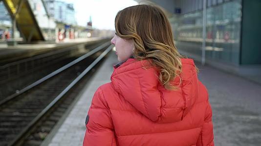 年轻女性在站台平台等火车视频的预览图