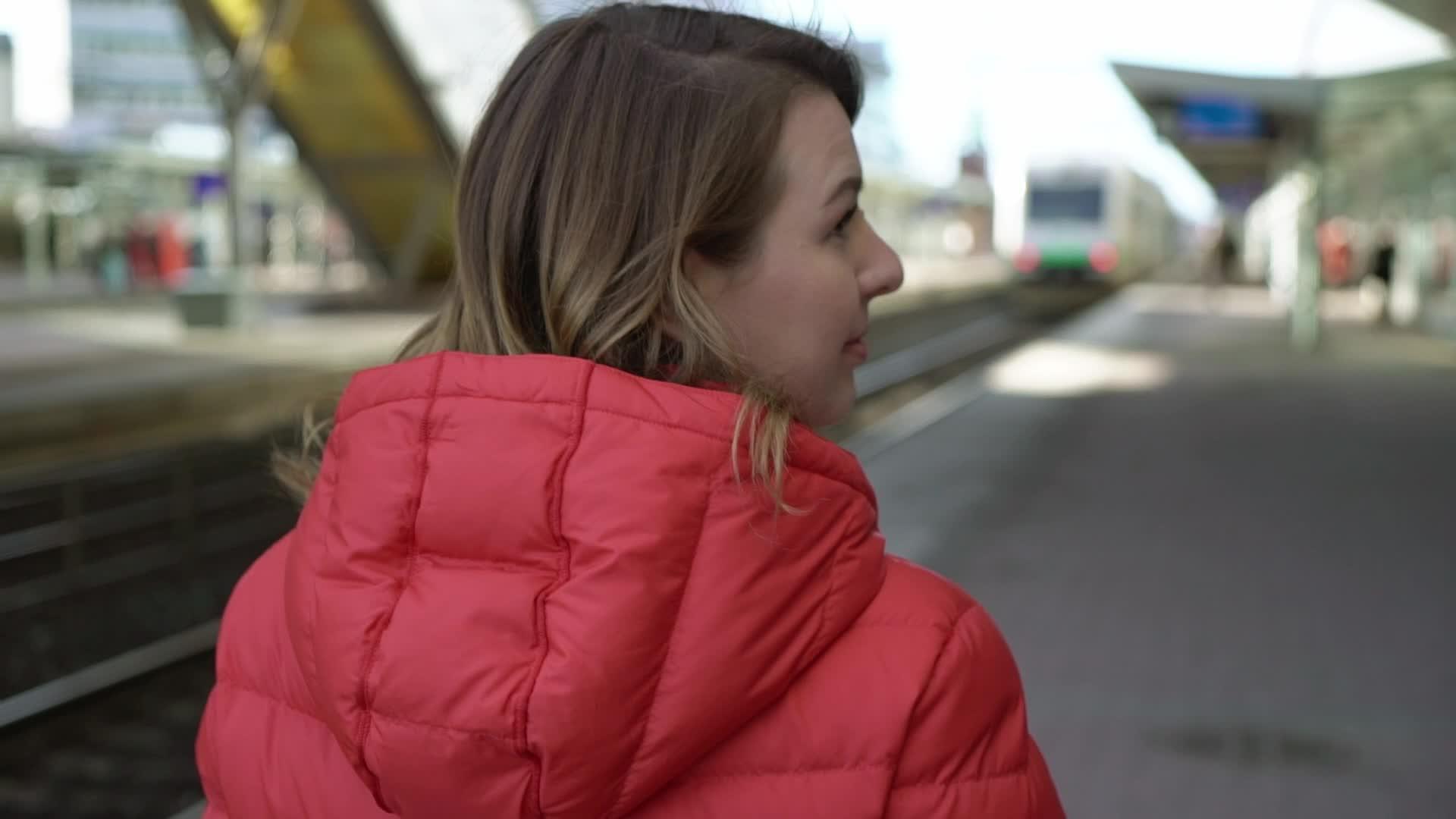 年轻女性在站台平台等火车视频的预览图