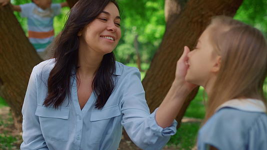 在野餐时微笑的母亲抚摸着女儿视频的预览图