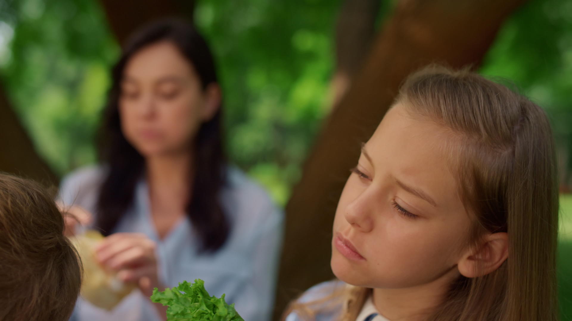 放松的女孩在野餐时吃三明治视频的预览图
