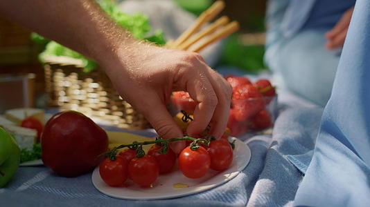在野餐特写中未知的人类手拿西红柿视频的预览图
