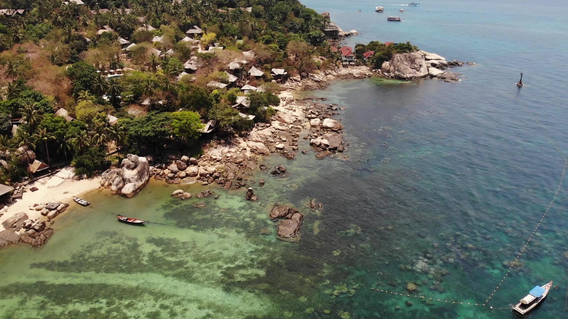 泰国热带岛屿上的小房子阳光明媚在宁静的海面上视频的预览图