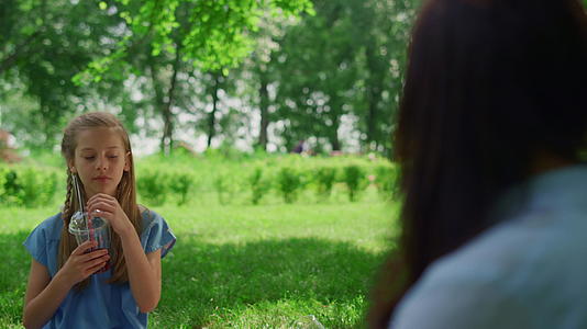 一个安静的女孩在野餐时拿着饮料视频的预览图
