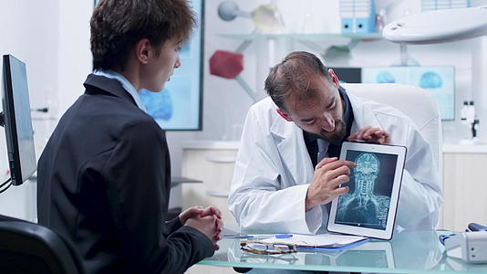 一名男医生在平板电脑上向一名年轻女性患者展示X光扫描视频的预览图
